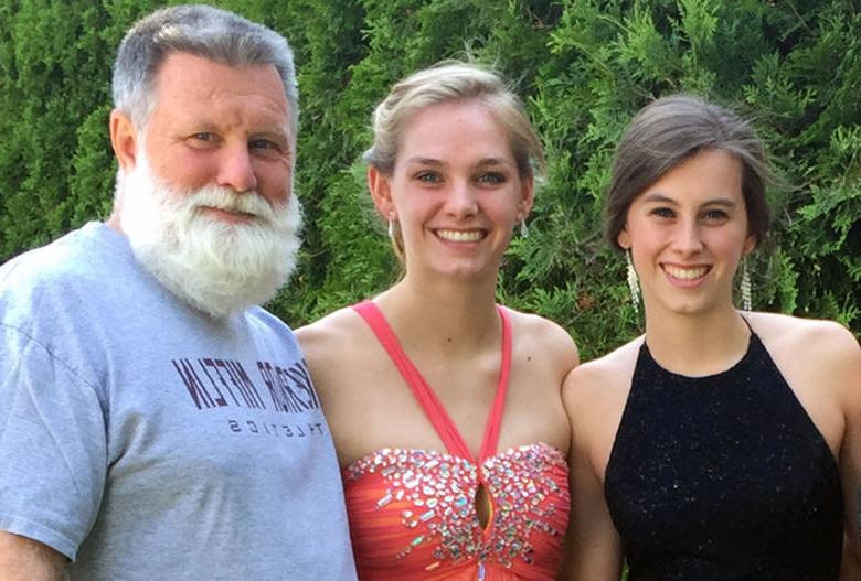 Two female 宾州州立银行 graduates with their father.